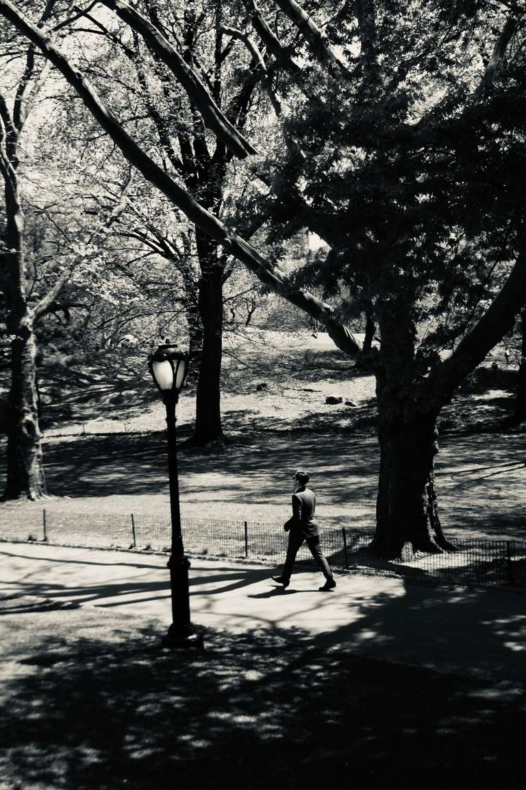 photo of a man walking by a lamp post